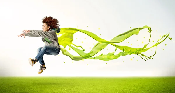 Hübsches Mädchen springt mit grünem abstrakten flüssigen Kleid — Stockfoto