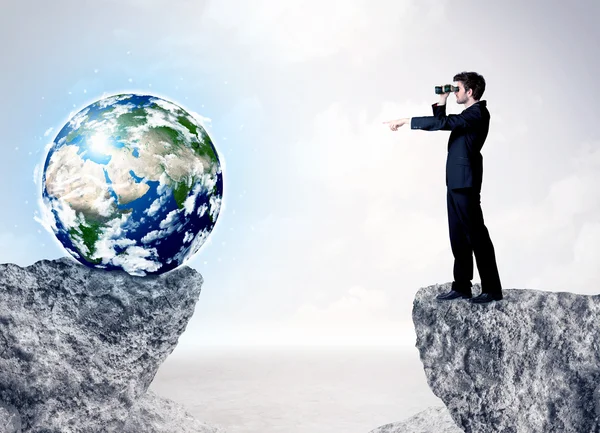 Businessman on rock mountain with a globe — Stock Photo, Image