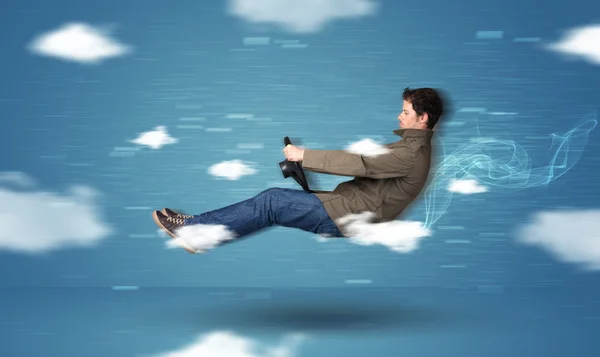 Funny racedriver young man driving between clouds concept — Stock Photo, Image