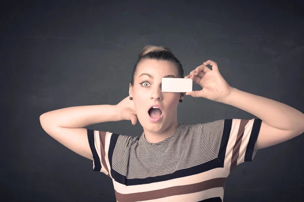 Pretty girl holding blank copy space paper at her eyes — Stock Photo, Image