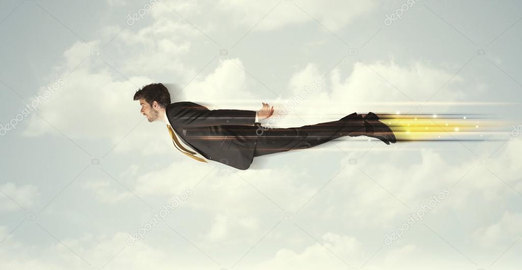 Happy business man flying fast on the sky between clouds