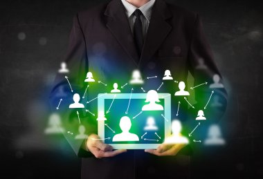 Yeşil sosyal medya simgeleriyle tablet sunan genç kişi