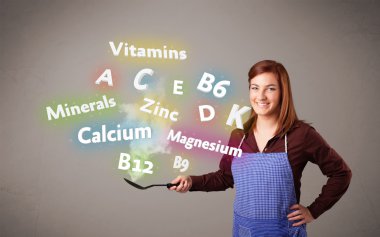 Genç bir kadın vitamin ve mineral pişiriyor.