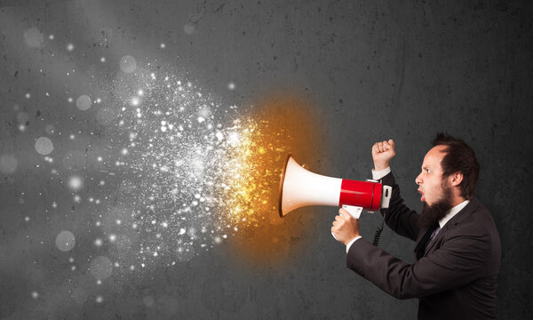 Парень, кричащий в мегафон и пылающие частицы энергии взрываются