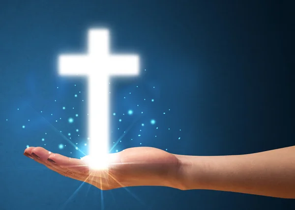 Glowing cross in the hand of a woman — Stock Photo, Image