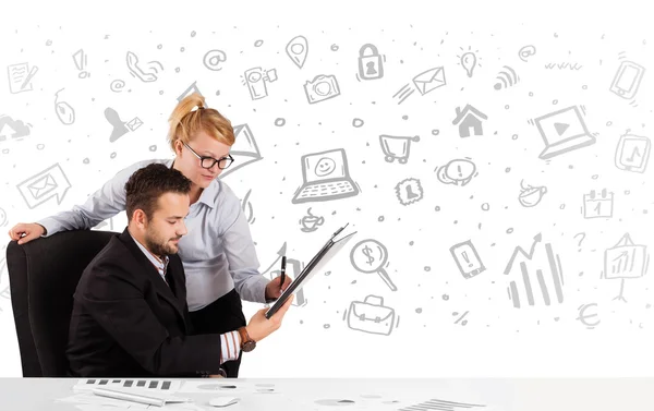 Business man en vrouw zitten aan tafel met de hand getekende media ic — Stockfoto