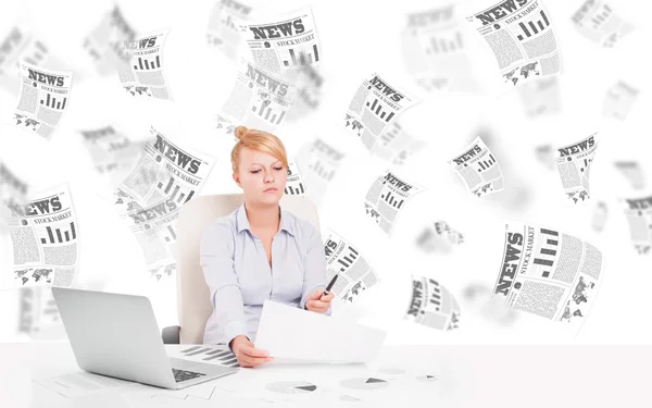 Mujer de negocios en el escritorio con periódicos bursátiles — Foto de Stock