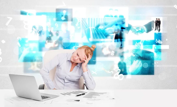 Geschäftsmann am Schreibtisch mit modernen Tech-Bildern im Hintergrund — Stockfoto