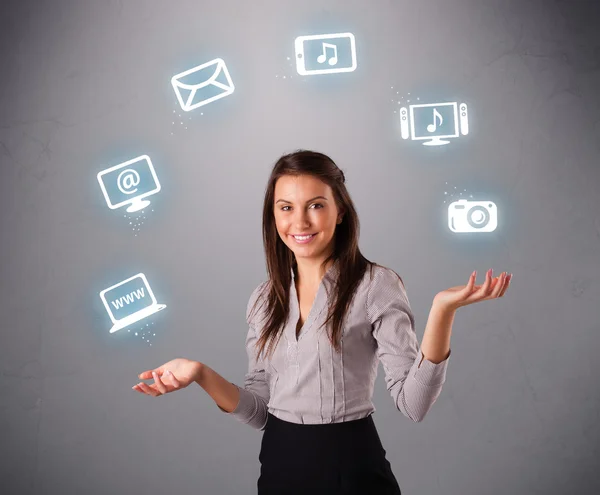 Pretty girl juggling with elecrtonic devices icons — Stock Photo, Image