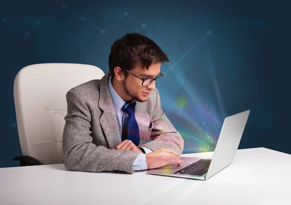 Handsome man sitting at desk and typing on laptop with abstract — Stock Photo, Image