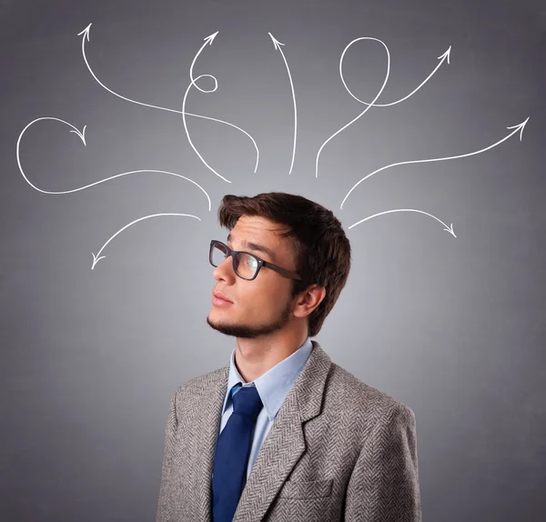 Young man thinking with arrows overhead — Stock Photo, Image