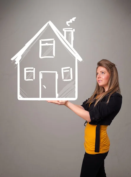 Young lady holding a huge drawn house — Stock Photo, Image