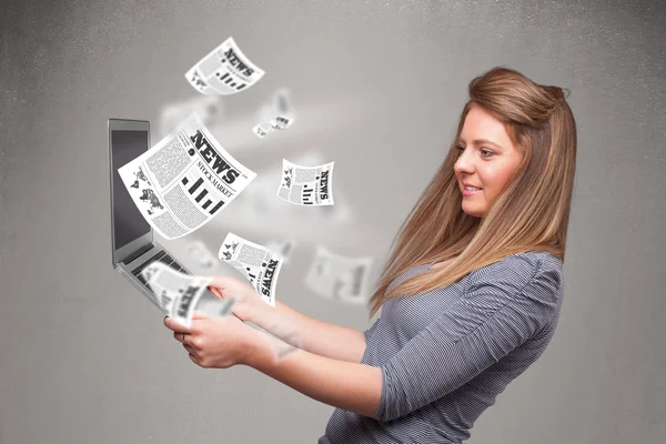 Casual jovem mulher segurando notebook e lendo o explosivo novo — Fotografia de Stock