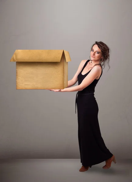 Elinde boş bir karton kutu tutan genç bir kadın. — Stok fotoğraf