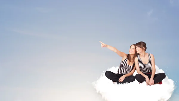 Junge Frauen sitzen mit Kopierraum auf Wolke sieben — Stockfoto