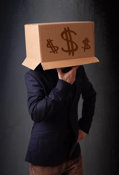 Young man gesturing with a cardboard box on his head with dollar — Stock Photo, Image