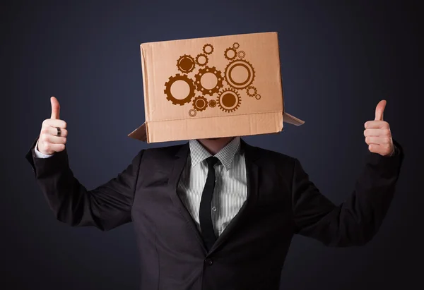 Young man gesturing with a cardboard box on his head with spur w — Stock Photo, Image