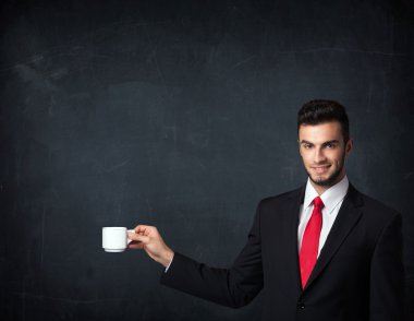 Beyaz bir bardak tutan işadamı