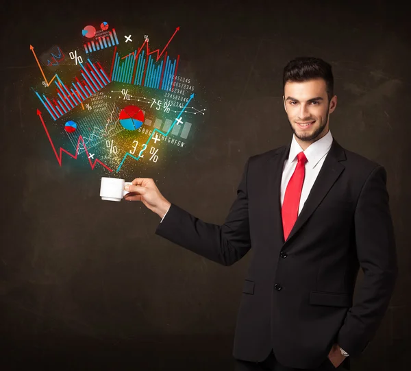 Affärsman hålla en vit kopp med diagram och grafer — Stockfoto