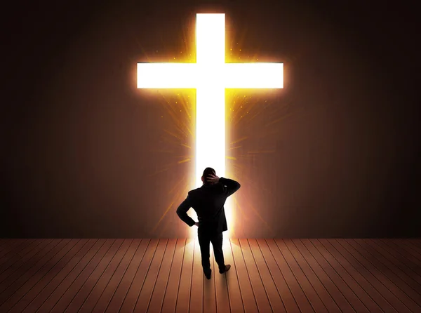 Man looking at bright cross sign — Stock Photo, Image