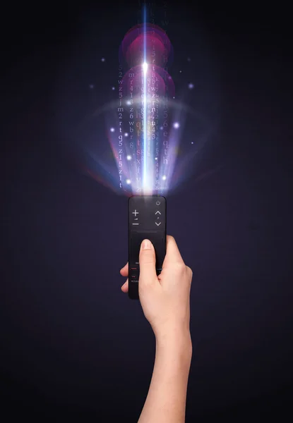 Hand with remote control and shining numbers — Stock Photo, Image