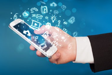Medya simgeleri ve sembolleriyle el ele tutuşan akıllı telefon 