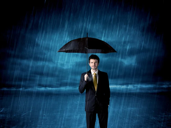 Homem de negócios de pé na chuva com um guarda-chuva — Fotografia de Stock