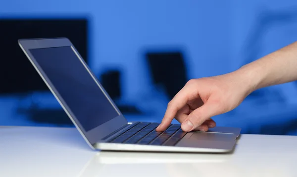 Empresário pressionando computador portátil moderno em backgrou colorido — Fotografia de Stock