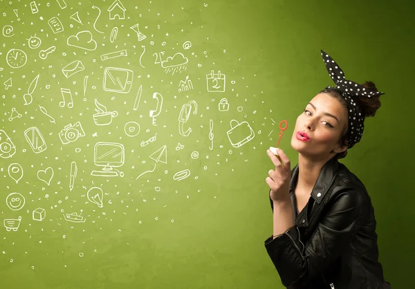 Cute girl blowing hand drawn media icons and symbols — Stock Photo, Image