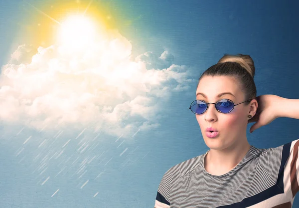 Young person looking with sunglasses at clouds and sun — Stock Photo, Image