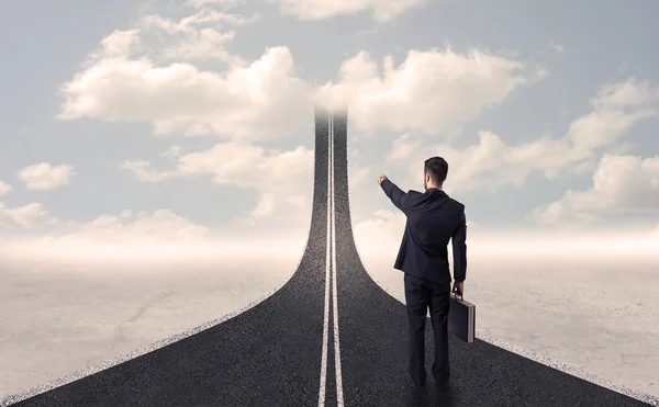 Businessman looking at 3d road that goes up in the sky — Stock Photo, Image