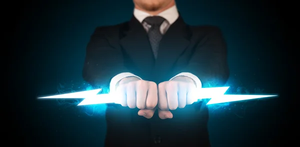 Business man holding glowing lightning bolt in his hands — Stock Photo, Image