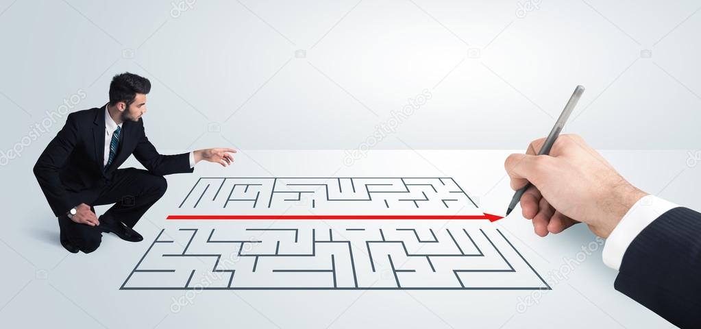 Business man looking at hand drawing solution for maze 