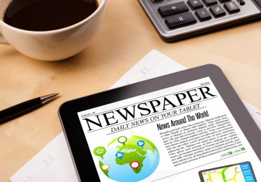 Tablet bilgisayarı haberleri ekranda bir fincan kahveyle sunar.