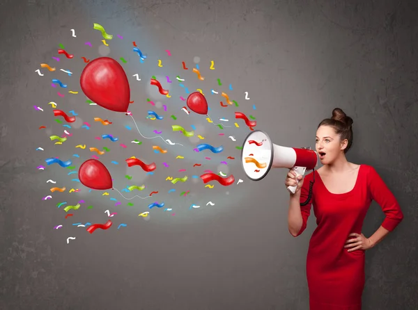 Ung flicka har kul, skriker in i megafon med ballonger — Stockfoto