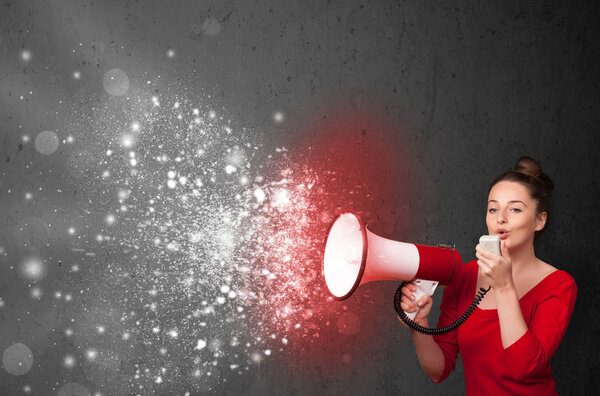 Женщина кричит в мегафон и исследует светящиеся частицы энергии
