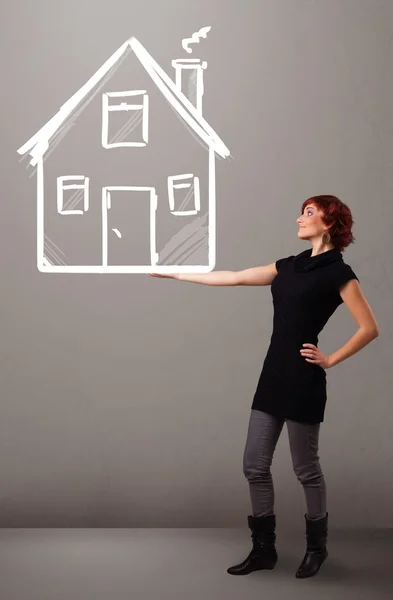 Young lady holding a huge drawn house — Stock Photo, Image