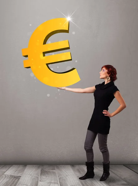 Gyönyörű lány kezében egy nagy 3D arany euro jel — Stock Fotó