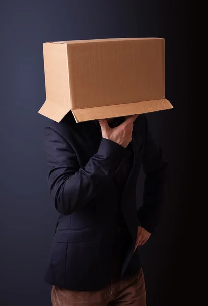 Young man gesturing with a cardboard box on his head — Stock Photo, Image