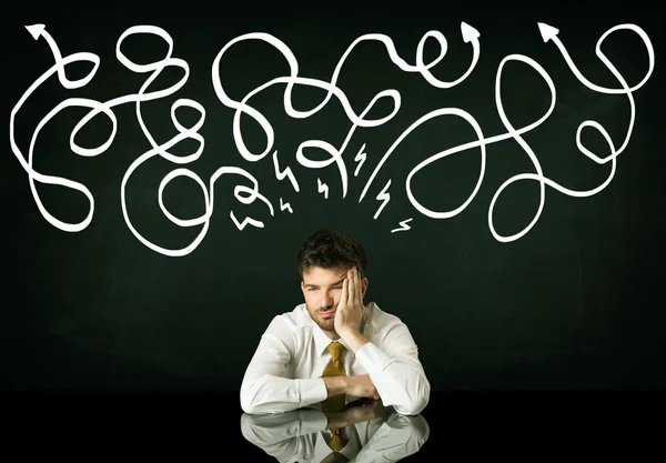 Depressed businessman sitting under drawn direction lines — Stock Photo, Image