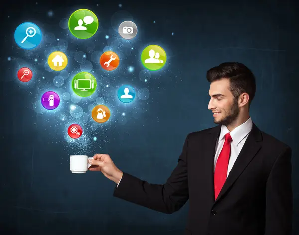 Businessman holding a white cup with setting icons — Stock Photo, Image