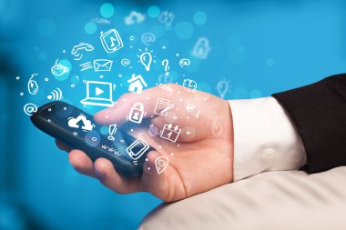 Medya simgeleri ve sembolleriyle el ele tutuşan akıllı telefon 