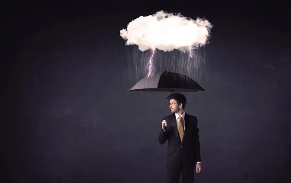 Empresario de pie con paraguas y pequeña nube de tormenta —  Fotos de Stock