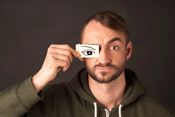 Silly youngster looking with hand drawn eye paper — Stock Photo, Image