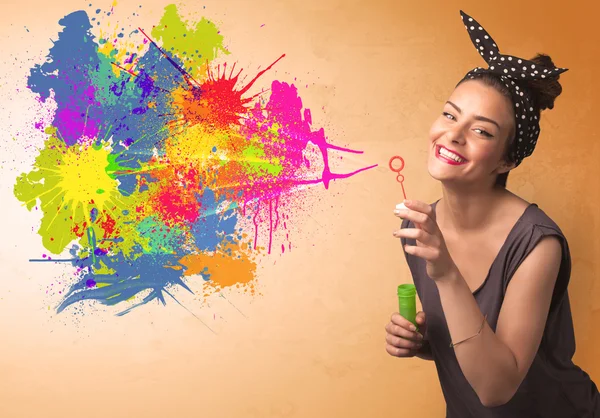 Schattig meisje blazen kleurrijke splash graffiti — Stockfoto