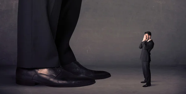 前の概念に立っている小さなビジネスマンと巨大な足 — ストック写真