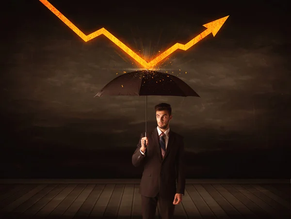 Businessman standing with umbrella keeping orange arrow — Stock Photo, Image