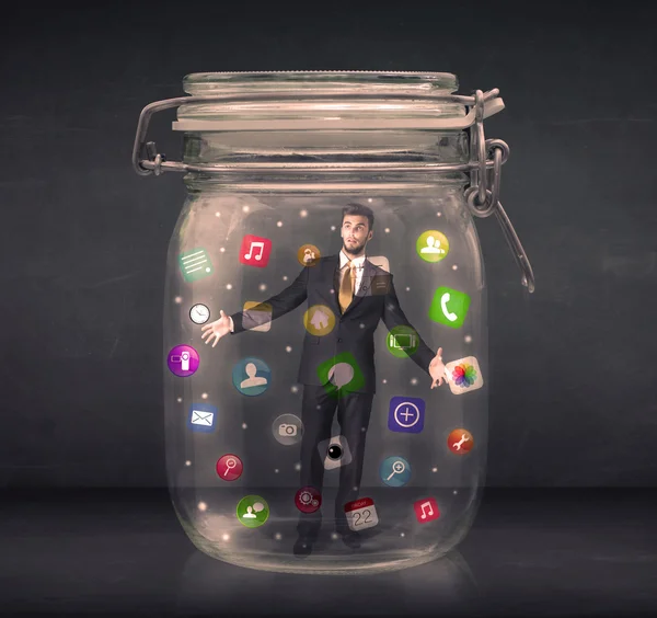 Businessman captured in a glass jar with colourful app icons con — Stock Photo, Image