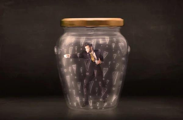 Business man trapped in jar with exclamation marks concept — Stock Photo, Image