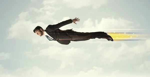 Happy business man flying fast on the sky between clouds — Stock Photo, Image